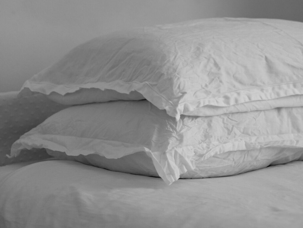 Witte hoofdkussens op een opgemaakt bed