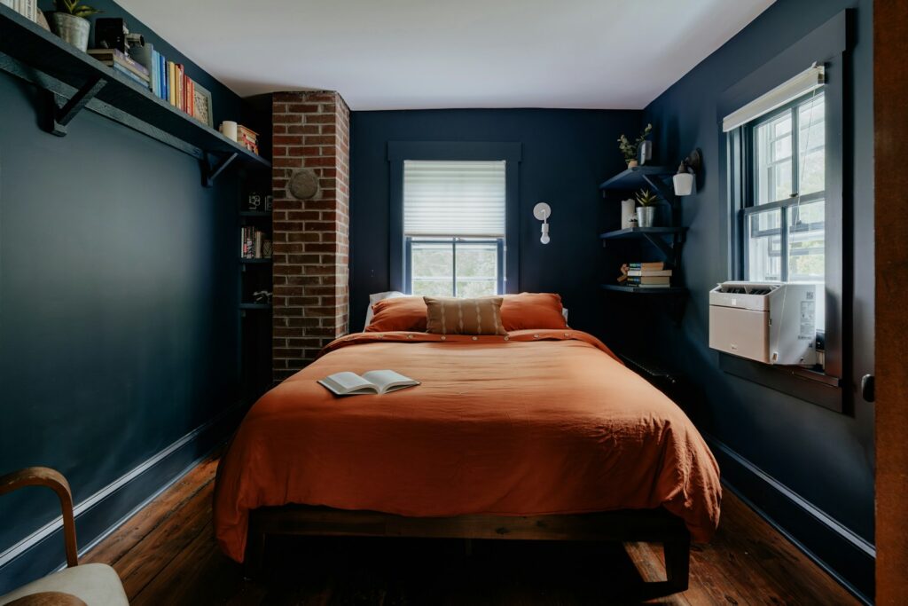 Opgemaakt bed in een lichte slaapkamer met een half geopend raam