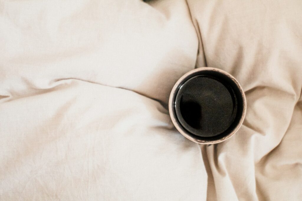 Iemand die op zaterdagochtend uitslaapt in een opgemaakt bed