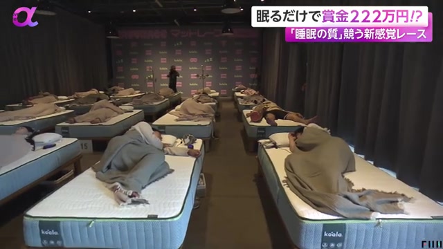 Deelnemers slapen op rijen matrassen in een zaal tijdens een slaapwedstrijd in Tokio